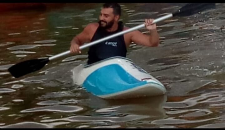 Christian remando em um caiaque no rio