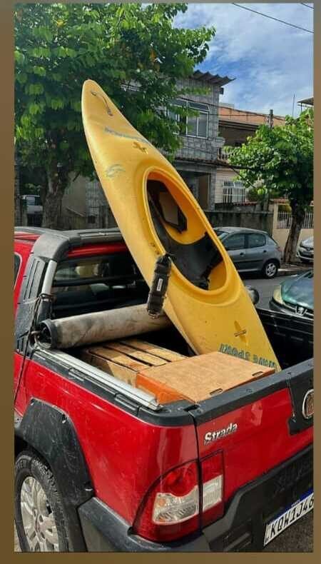 Caiaque amarelo sendo entregue na caçamba de uma caminhonete